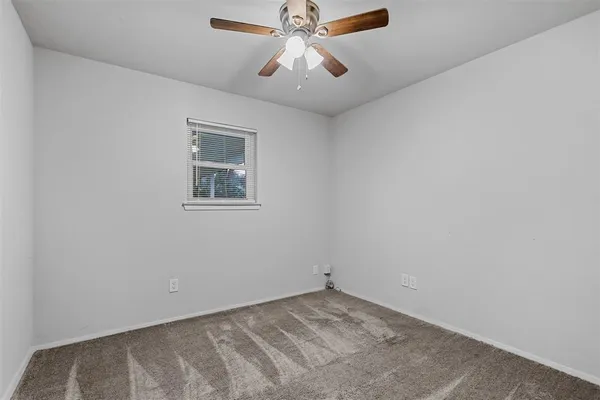 an empty room with chandelier fan