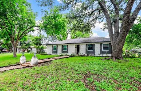 a view of a house with a yard and trees