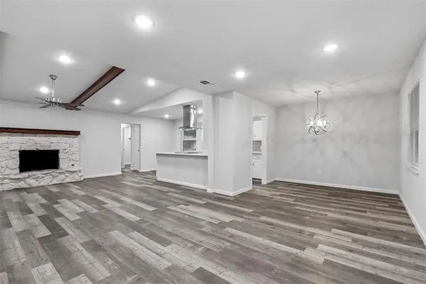 a view of an empty room with a fireplace and a window