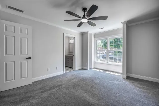 a view of a livingroom with a ceiling fan & windows