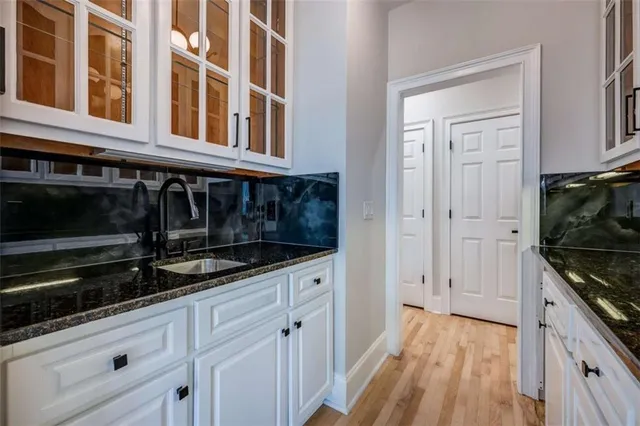 a kitchen with granite countertop a stove and white cabinets