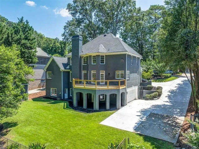a front view of house with yard and trees in the background