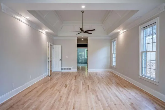 a view of a room with a ceiling fan large window and wooden floor