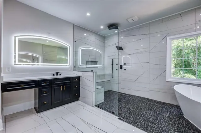 a spacious bathroom with a granite countertop sink a toilet and bathtub