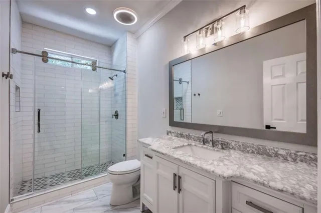 a bathroom with a granite countertop sink toilet and shower
