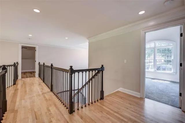 a view of a hallway with wooden floor and windows