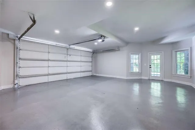 an empty room with windows fireplace and a sink