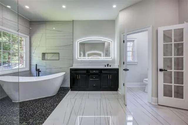 a spacious bathroom with a bathtub shower and toilet