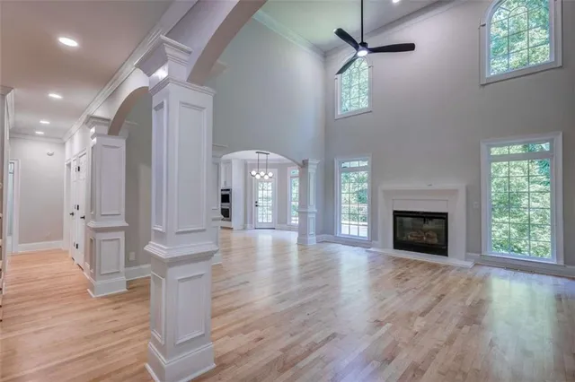 a view of an empty room with wooden floor fireplace and a window