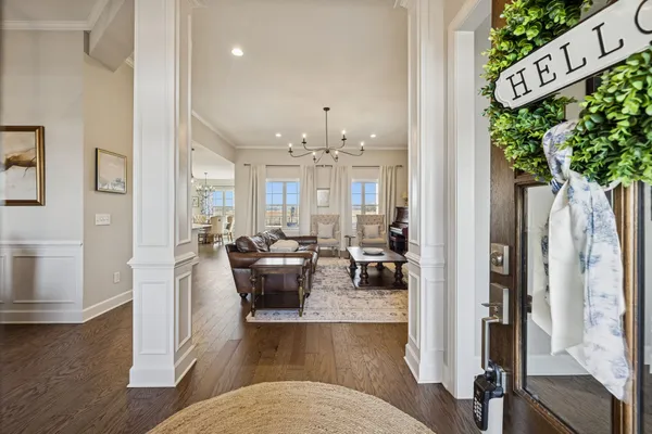 a living room with furniture kitchen view and a chandelier