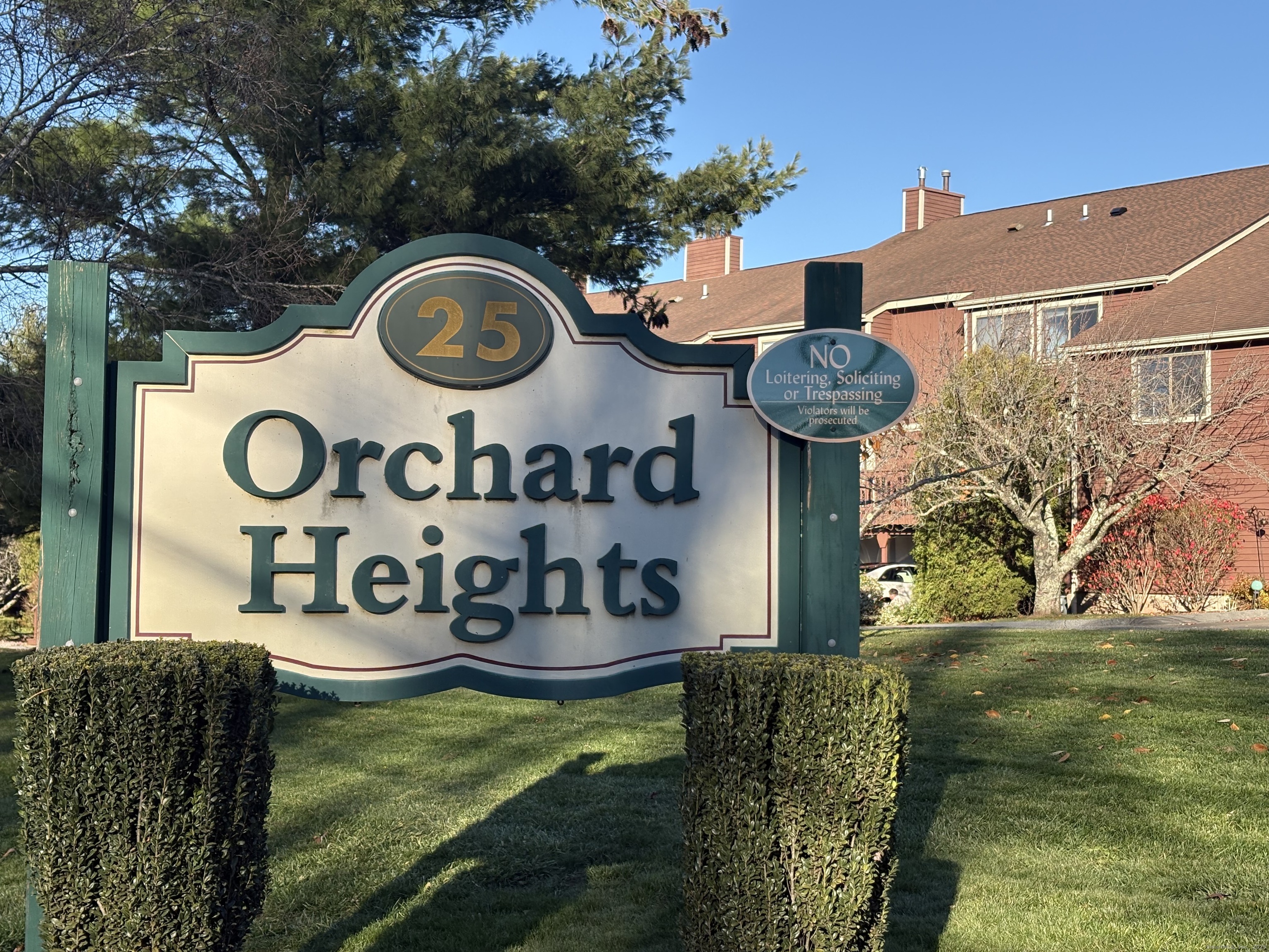 a front view of a house with garden and trees