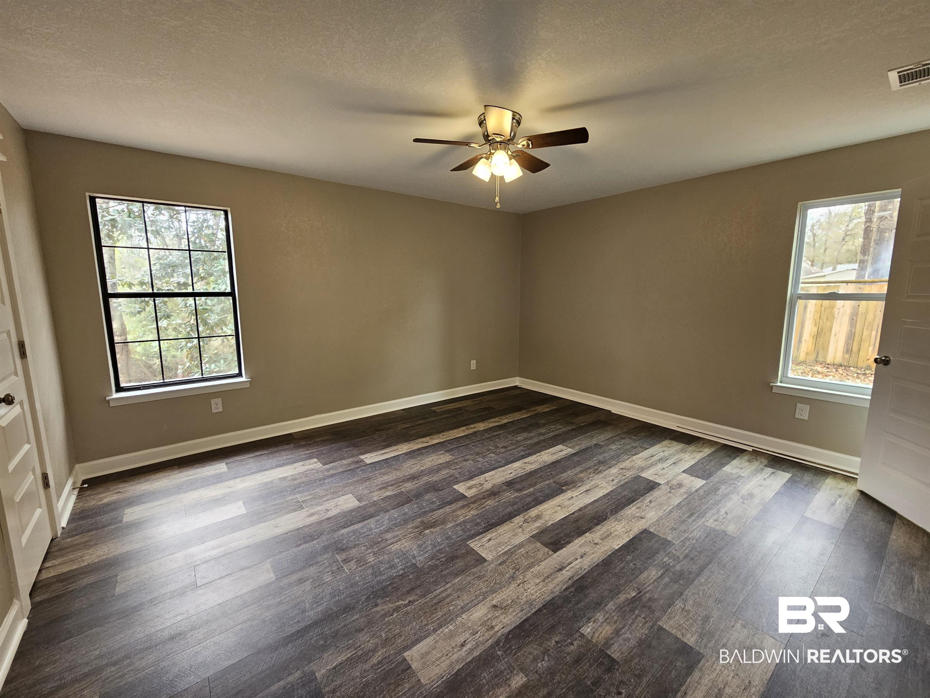 138 Wicker Way Daphne, AL 36526 - Photo 16 of 32 Unfurnished room with dark wood-style flooring, a textured ceiling, and a ceiling fan