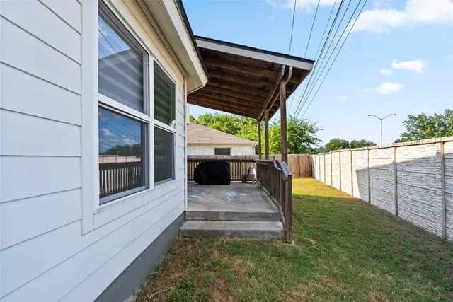 a view of a house with backyard and wooden fence