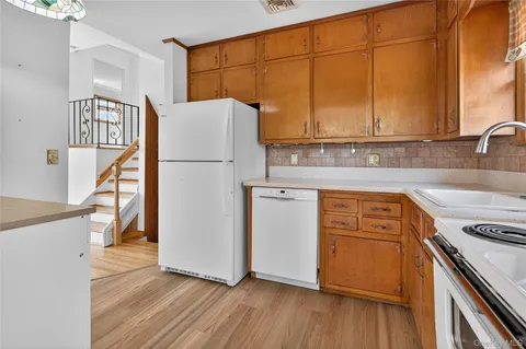 a kitchen with a refrigerator a sink and wooden floor