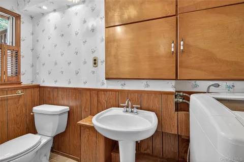 a bathroom with a sink a toilet and mirror