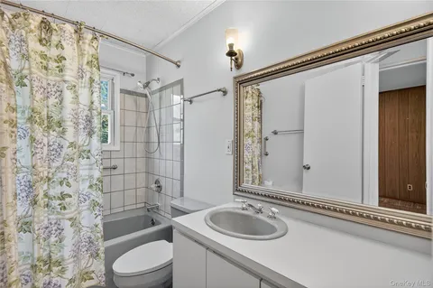 a bathroom with a granite countertop sink toilet a mirror and shower