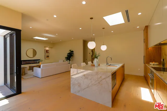 a kitchen with stainless steel appliances a dining table chairs and a refrigerator