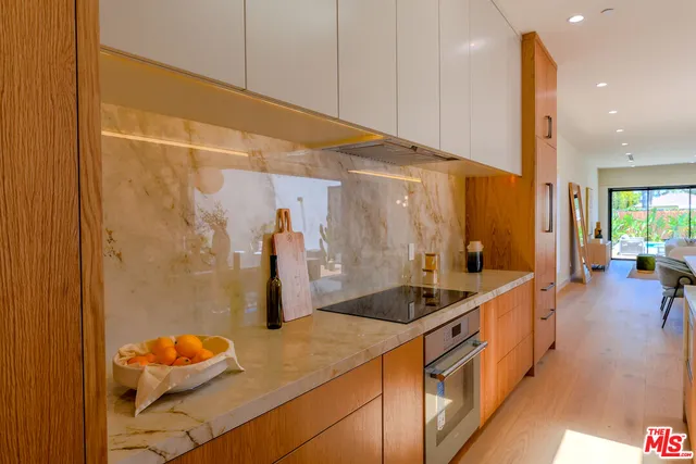a large kitchen with stainless steel appliances lots of counter space and a sink