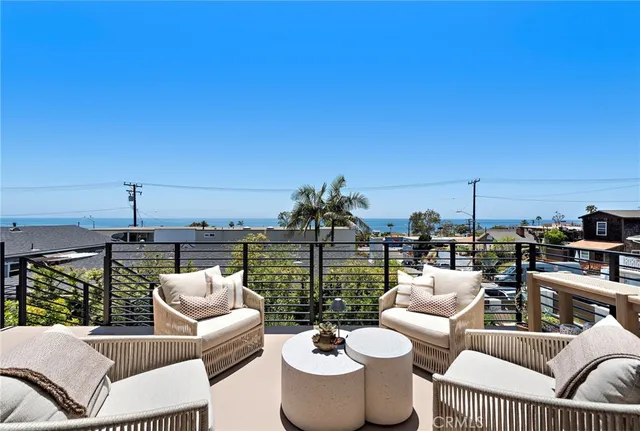 a view of a balcony with chairs and a potted plant