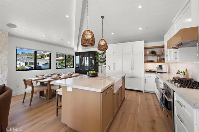 a kitchen with a stove a wooden floor a dining table and chairs