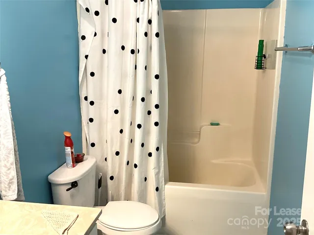 a white toilet sitting next to a bath tub