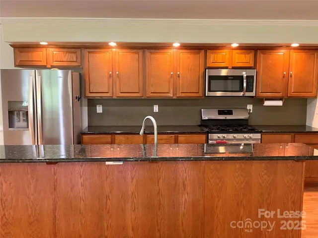 a kitchen with stainless steel appliances a sink and a microwave