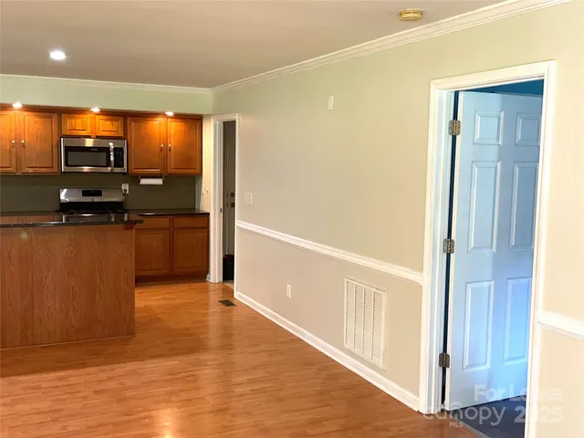 a view of kitchen with kitchen island wooden floor and living room