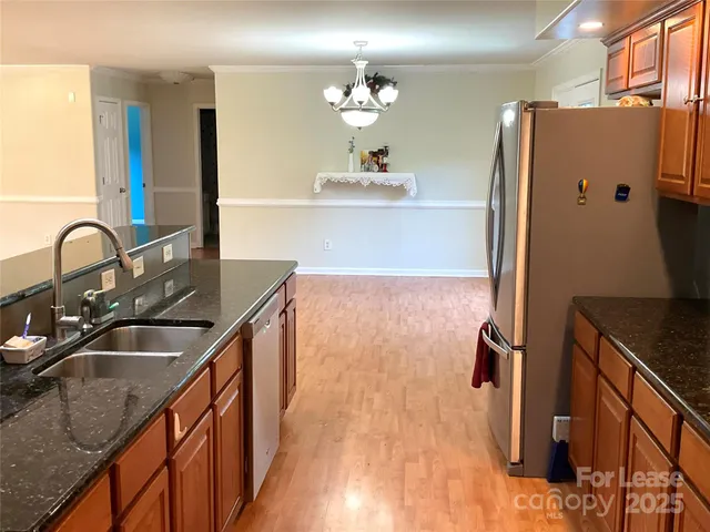 a kitchen with granite countertop a sink appliances and cabinets