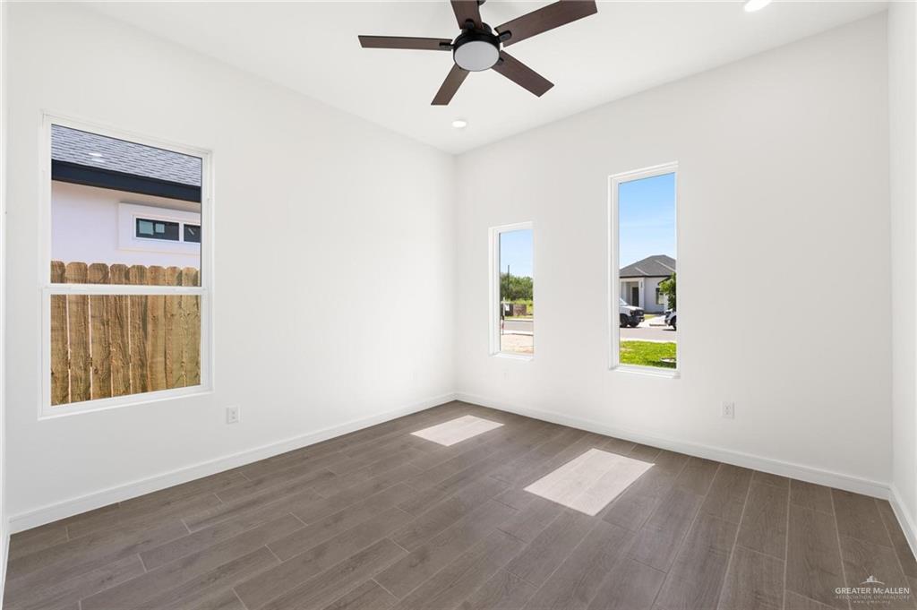 505 Freedom Way Weslaco, TX 78596 - Photo 8 of 20 a view of an empty room with a window and wooden floor