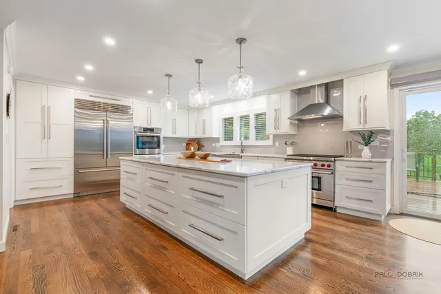 a kitchen with stainless steel appliances kitchen island granite countertop a refrigerator and a stove