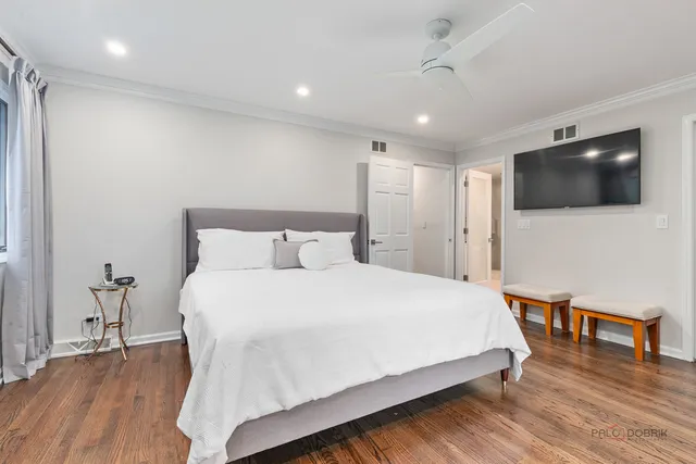 a spacious bedroom with a bed and a flat screen tv