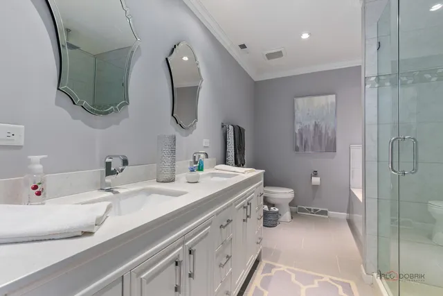 a bathroom with a double vanity sink mirror and toilet