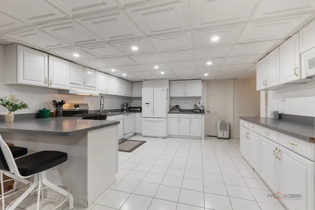 a kitchen with white cabinets a sink and white appliances