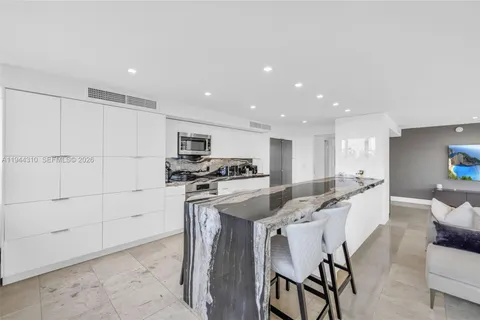 a kitchen with kitchen island a stove a table and chairs