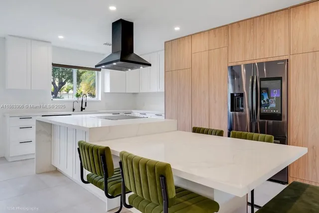 a kitchen with stainless steel appliances a table and window