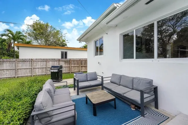 a view of a patio with couches and a table and chairs with garden view