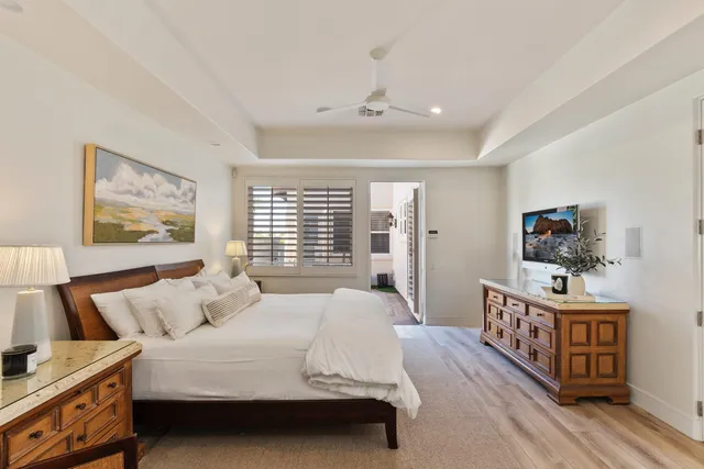 a bedroom with a large bed and a chandelier
