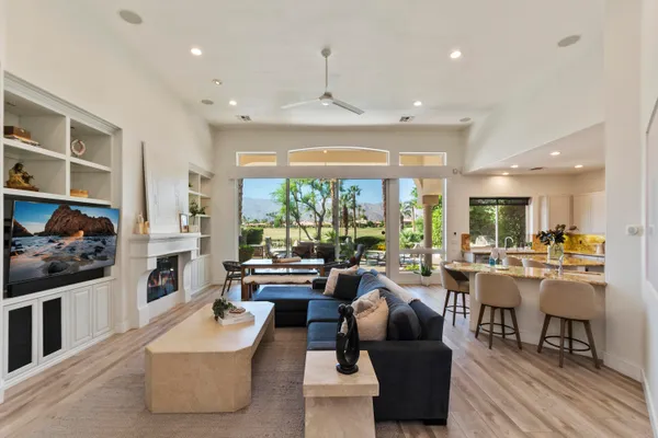 a living room with fireplace furniture and a large window