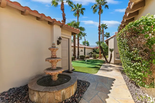a front view of multi story residential apartment building with yard and sign board