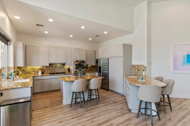 a kitchen with a dining table chairs and white appliances