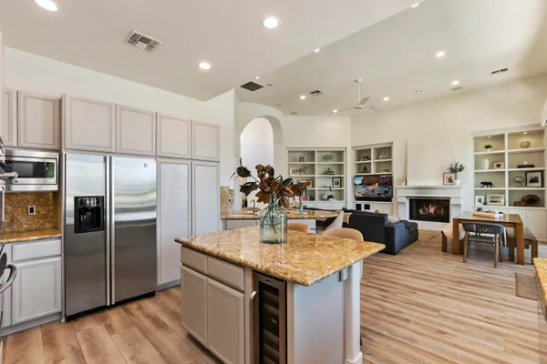 a kitchen with stainless steel appliances granite countertop a refrigerator and a stove top oven