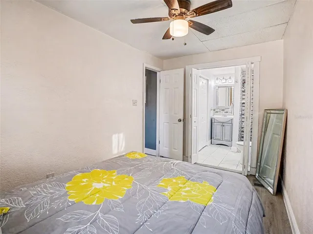 a view of a bedroom with a large bed and a chandelier fan