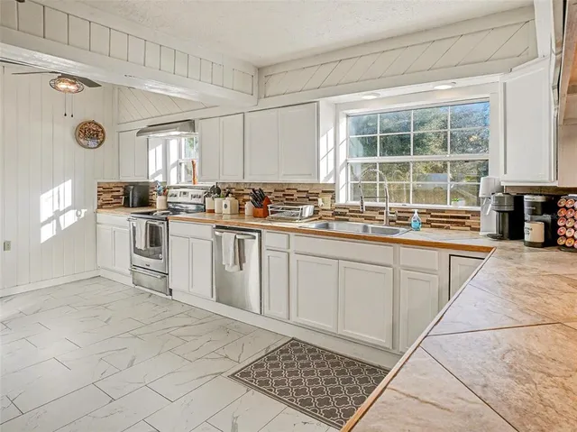a kitchen with a stove a sink a microwave and cabinets