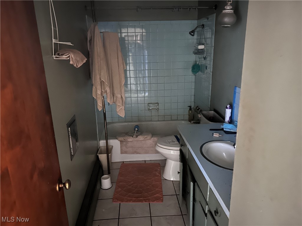 2813 Trares Road Mogadore, OH 44260 - Photo 7 of 16 Full bathroom featuring bathing tub / shower combination, tile patterned floors, vanity, and toilet