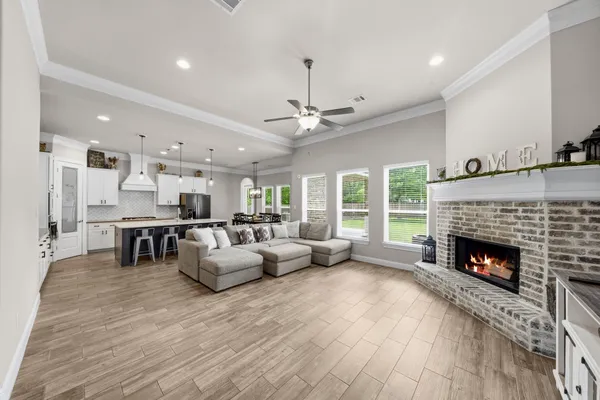 a view of a dining room and livingroom with furniture wooden floor a chandelier