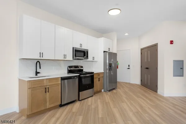 a kitchen with a sink a refrigerator and cabinets