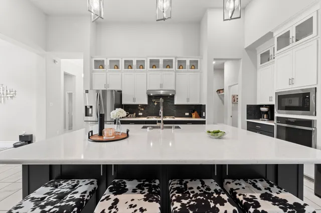 a kitchen with stainless steel appliances granite countertop a sink stove and cabinets
