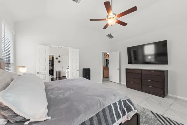 a spacious bedroom with a large bed and a flat screen tv