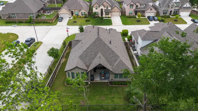 an aerial view of a swimming pool with a yard