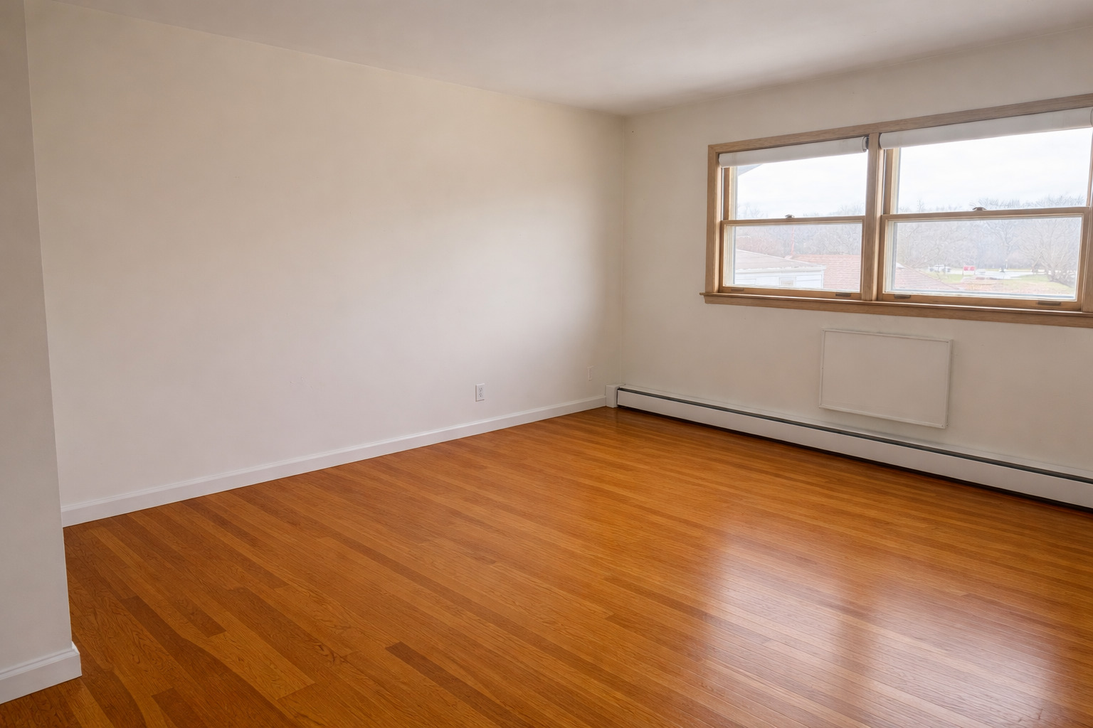 8304 W Forest, Unit 3W Chicago, IL 60634 - Photo 4 of 8 an empty room with wooden floor and windows